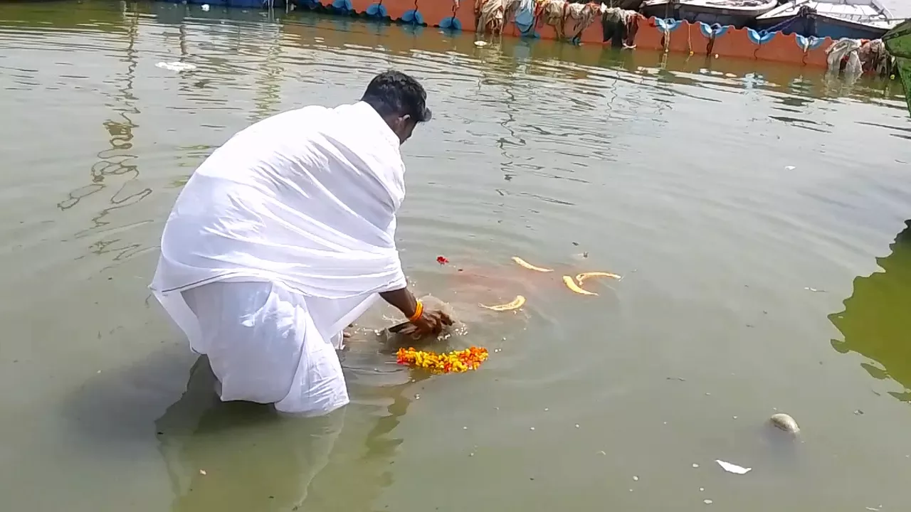 Image of a person give offering to ganga ji for their ancestors