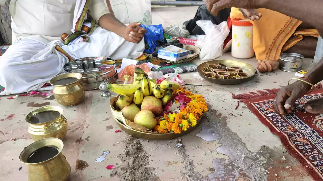 Image of a person offering fruits, flower and ask for blessing to their ancestors
