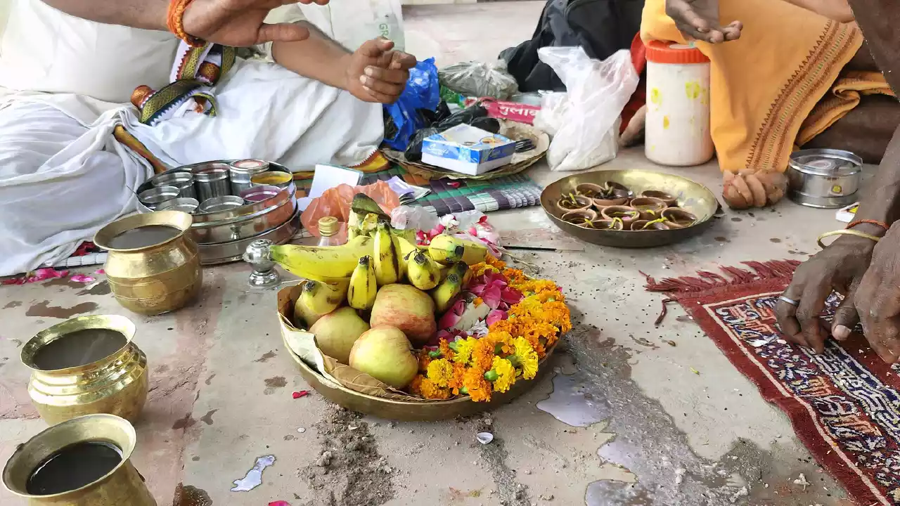 image of offering fruits and doing arti with diyas for their ancestors