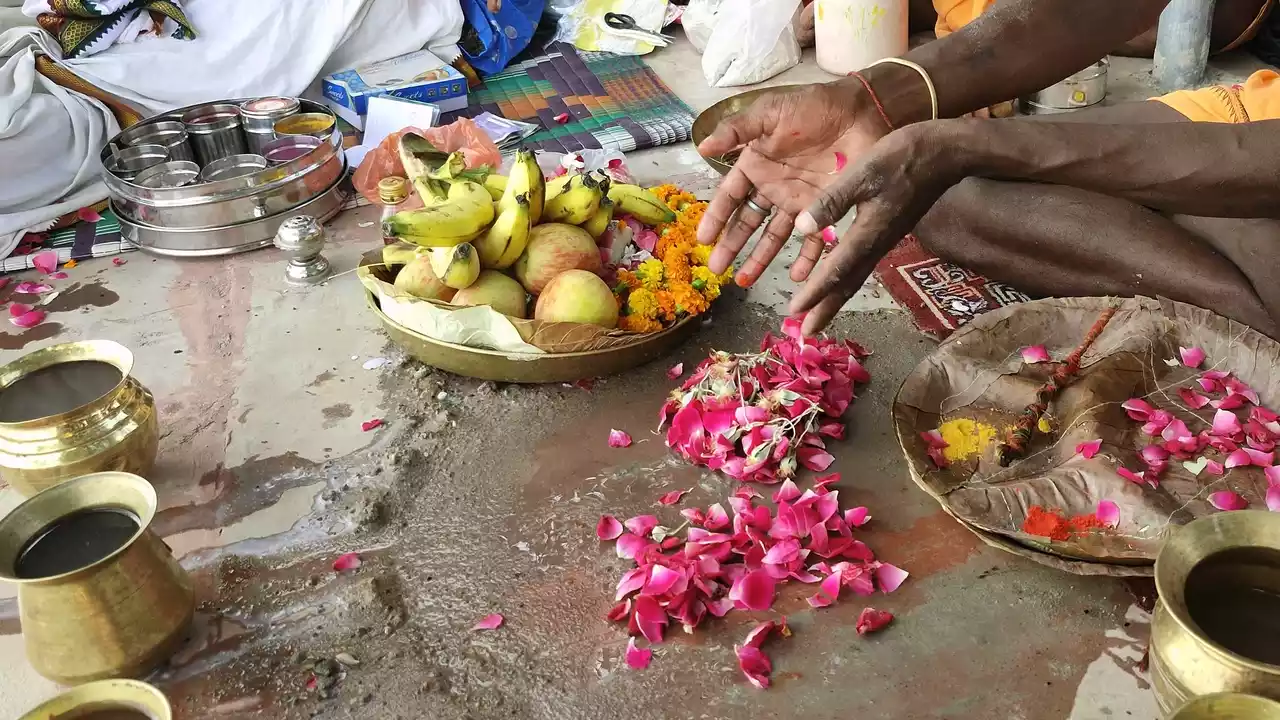 Image of a person doing hindu rituals offer flower to their ancestors