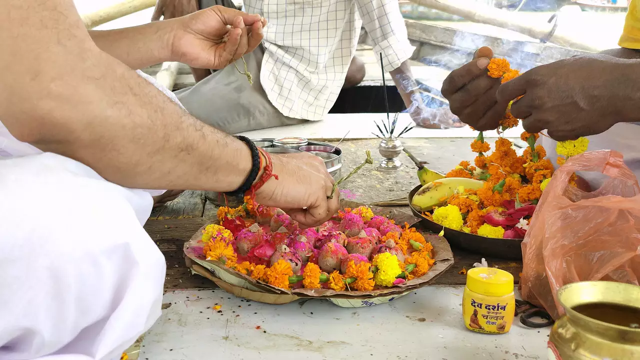 Image of A man offers Pind Daan (rice balls) during Shraddha, remembering ancestors.