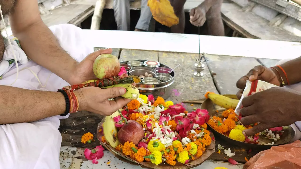 image of a man holding kusha and some fruit in his hand and doing rituals
