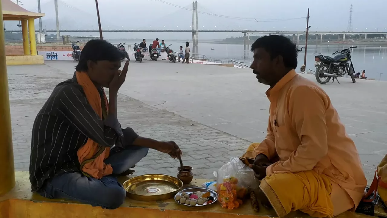 Image of A person sitting on the floor of temple and pandit ji doing hindu ritual on the Auspicious time, shradh rituals