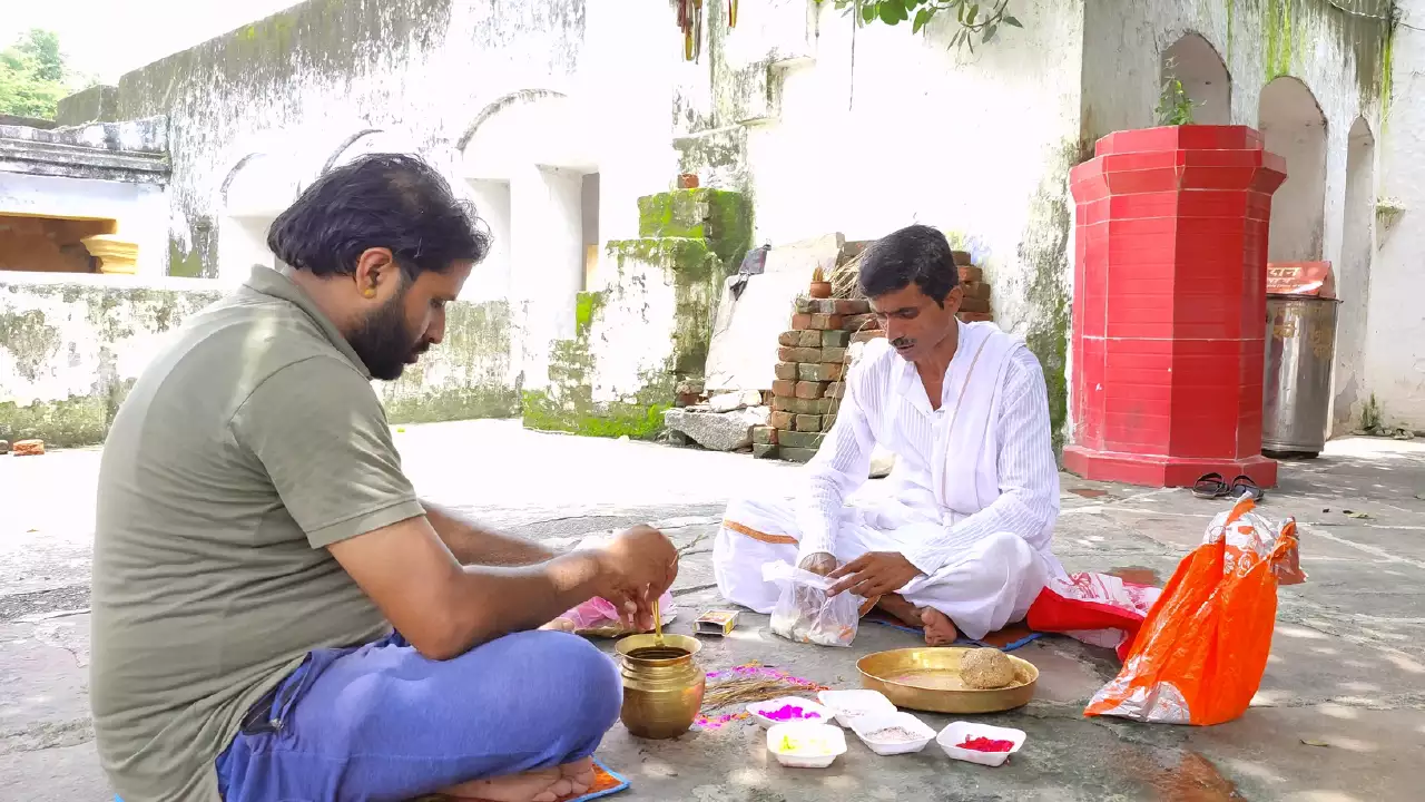 Image of A person sitting on the floor of temple and pandit ji doing hindu ritual on the Auspicious time, shradh rituals