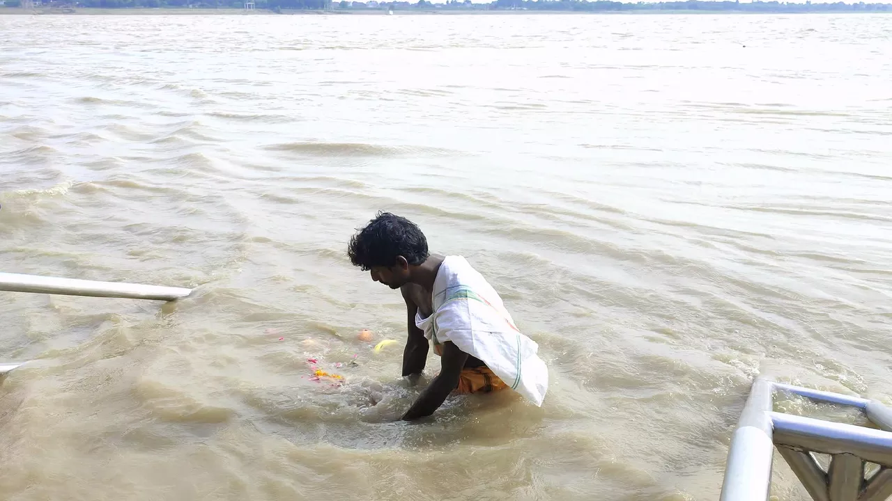 Photo of a devotee immersing pindas in ganga - From Pitra Dosha to Pitru Kripa
