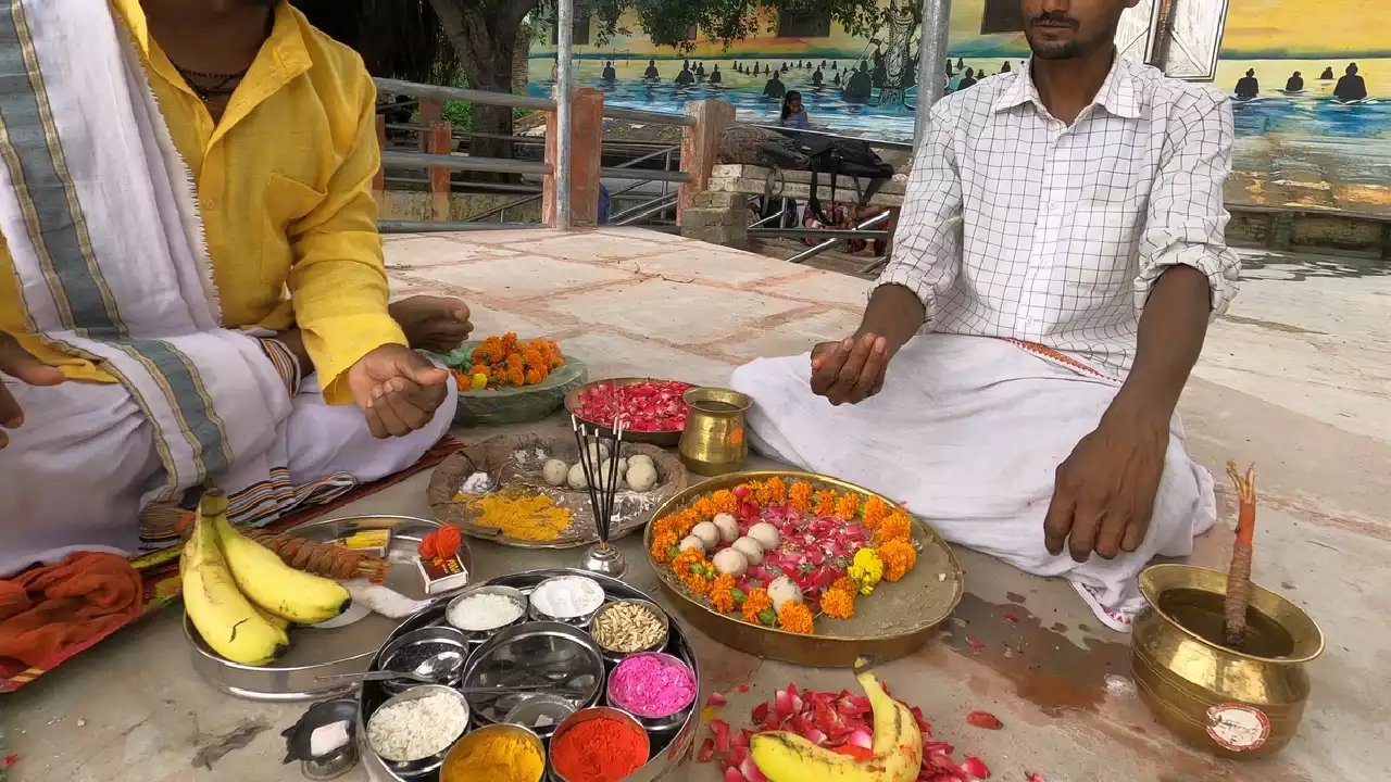 Image of Pind Daan ritual: Two men preparing offerings like Pindas, fruit, flowers, powders, altar- Pind Daan in Gaya significance