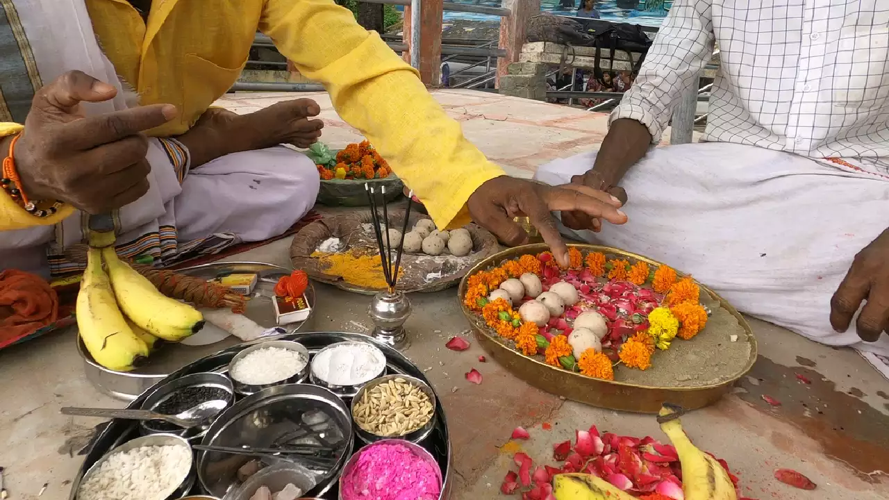 Image of Men performing Pind daan ceremony with pindas, flowers, incense, and other ritual offerings- Pind Daan scriptural basis
