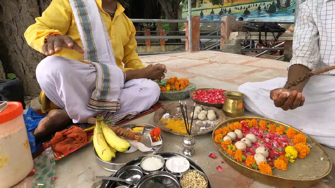 Two men performing Pind daan ritual with Pindas, flowers, fruits, powders, and a decorated altar- Pind Daan ingredients