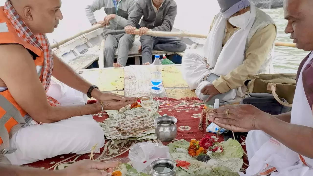 Images of Men perform Shraddha/Pind Daan rituals on a boat with offerings like Pindas. 