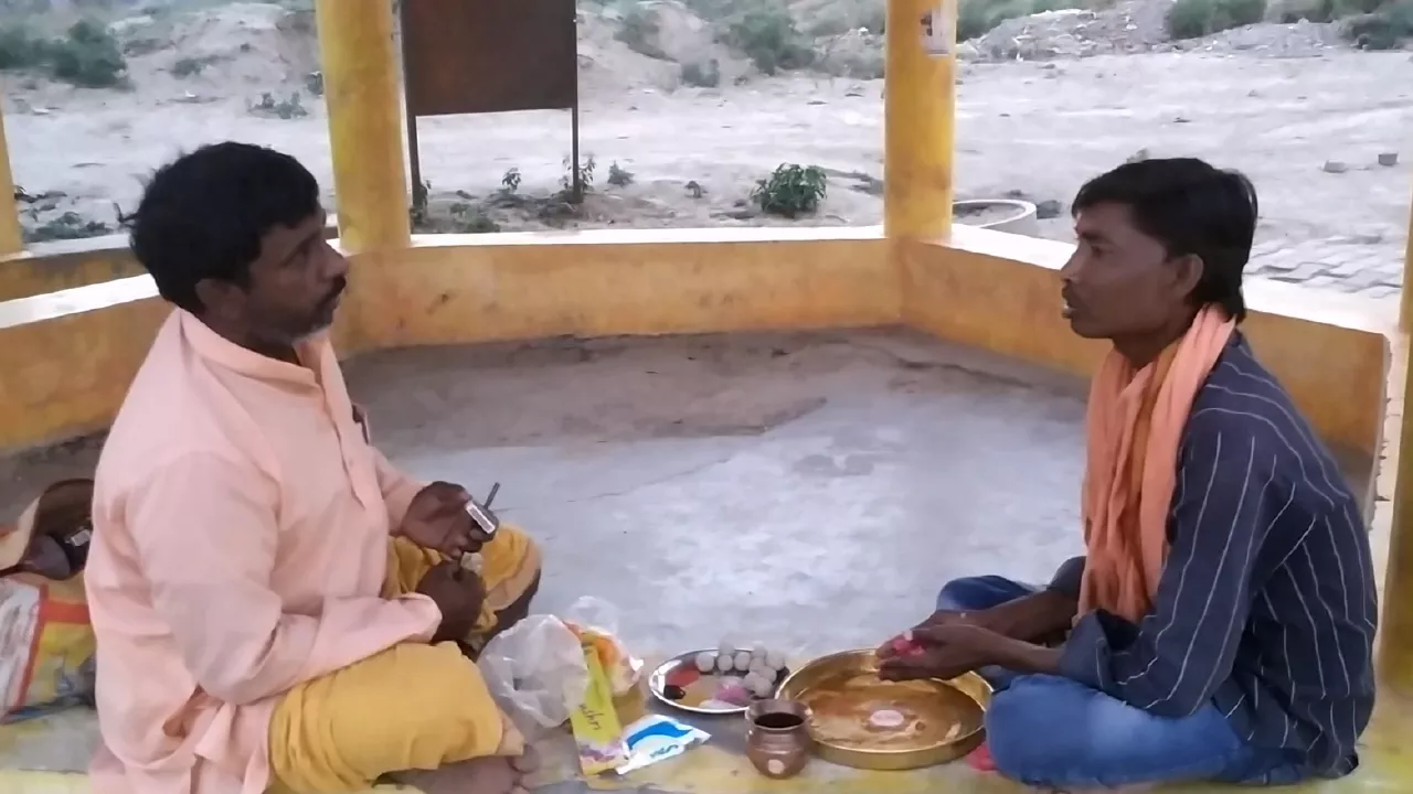 Two men sitting opposite each other, performing Pind daan ritual. Puja items laid out between them- What is Pind Daan