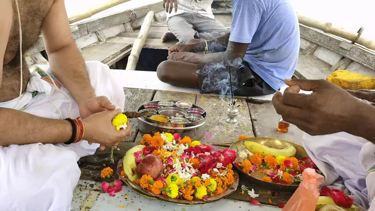 Images of Men perform Shraddha/Tarpan on a boat with fruit, flower, and incense offerings- Purpose of Tarpan