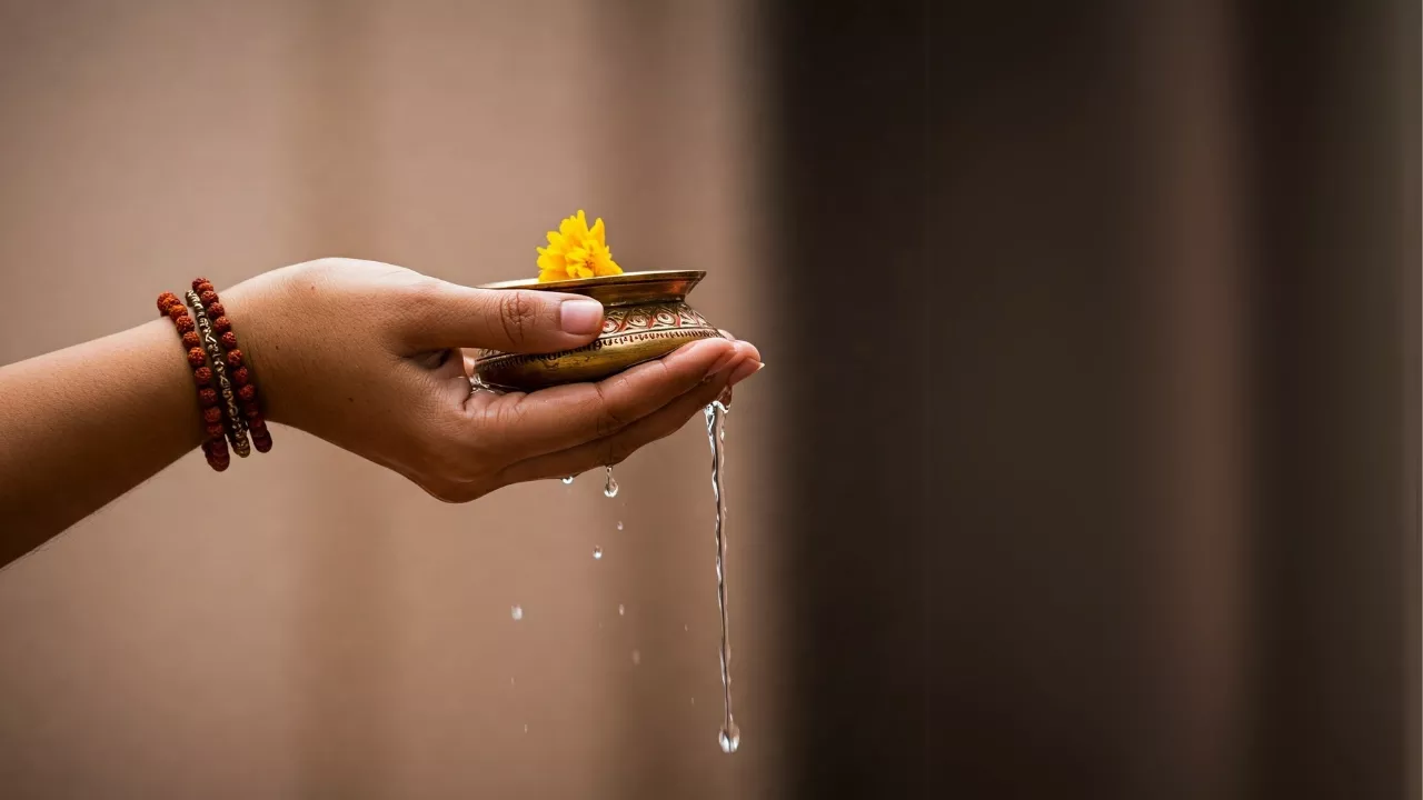 Image of Performing Tarpan, pouring water from a brass vessel with a flower as an offering- What is Tarpan